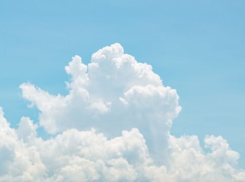 Serene image of fluffy white clouds against a bright blue sky, perfect for depicting calm and nature.