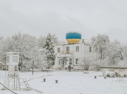 Serene winter scene with a snow-covered weather station and a blue dome in Kyiv, Ukraine.