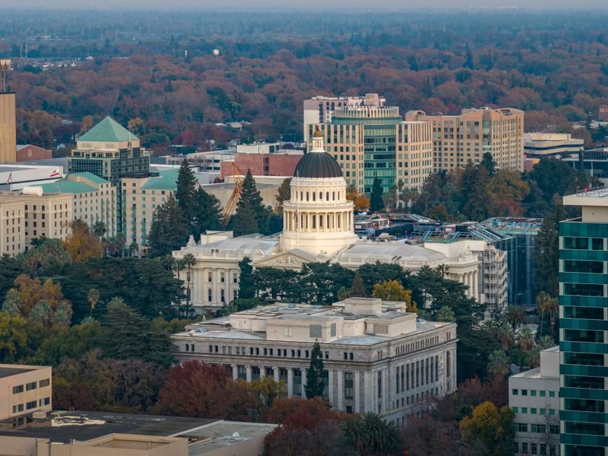 Stunning aerial view of the iconic California State Capitol in Sacramento surrounded by cityscape.