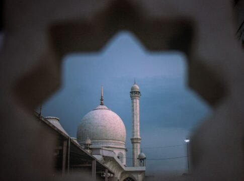 Stunning twilight view of Dargah Hazratbal Mosque in Srinagar seen through a decorative frame.