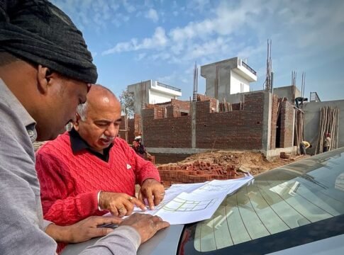 Team of architects examining building plans outdoors at a construction site. Team of architects examining building plans outdoors at a construction site.