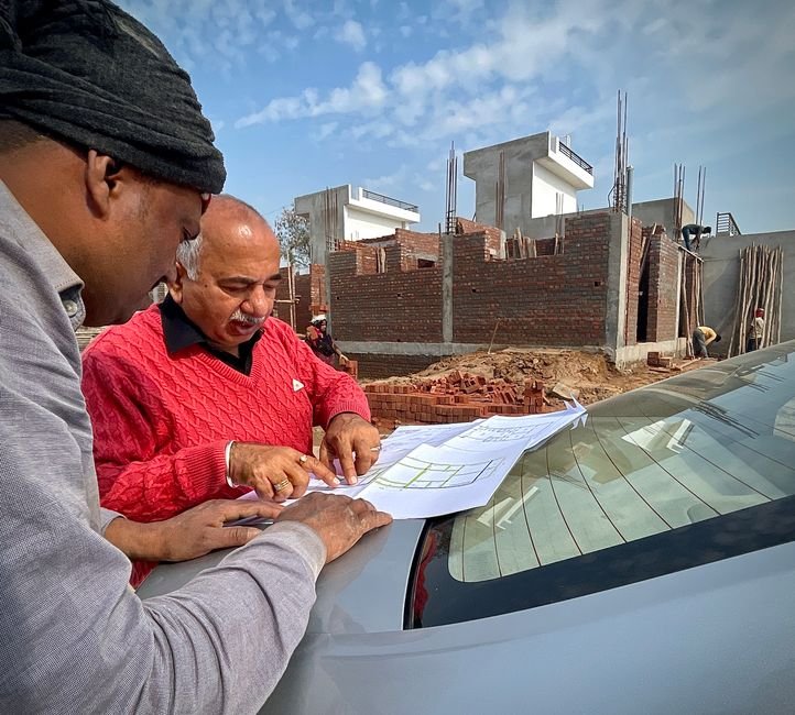 Madhya Pradesh: Defence Minister Inaugurates Tank Overhaul Facility, Hails Tanks as ‘Iron Wall’ Team of architects examining building plans outdoors at a construction site.