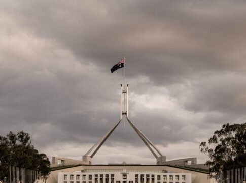 The Parliament House of Australia in Canberra with a dramatic cloudy backdrop.