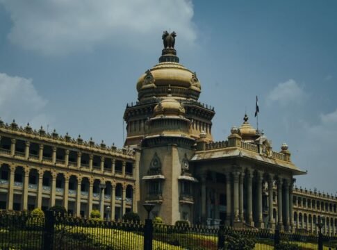 The majestic Vidhana Soudha in Bengaluru captured under a vibrant blue sky.