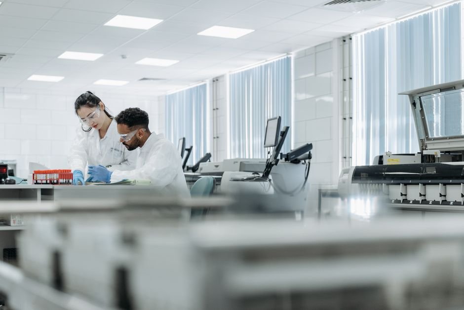 Canada Attracts Dozens of Elite U.S. Researchers Amid Global Talent Initiative Two scientists working in a high-tech laboratory setting, wearing protective eyewear and gloves.