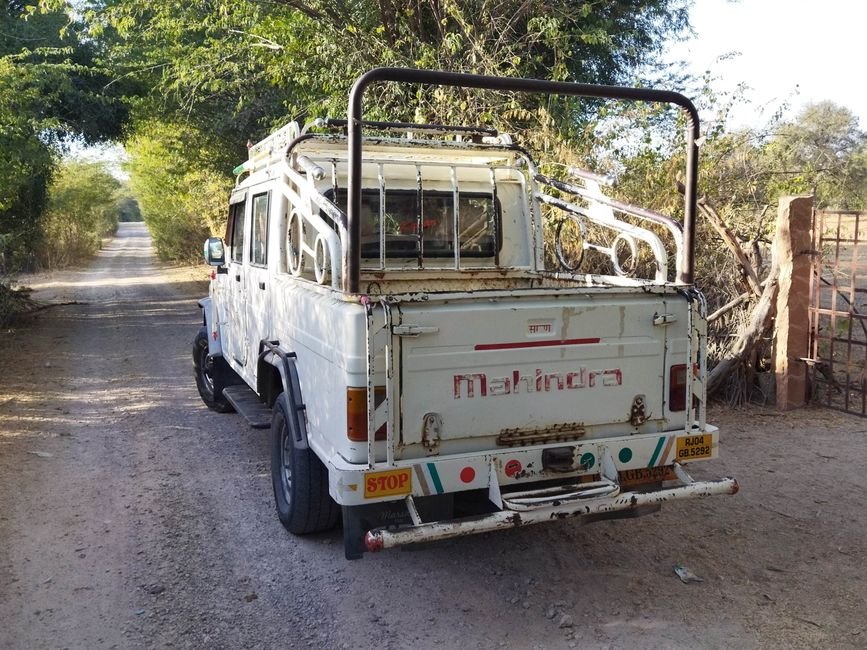 Jammu: Suspicious Scorpio Evades Ramban Checkpoint, Later Recovered Near Dalwas White Mahindra vehicle parked on a dirt road amidst green trees, captured in daylight.