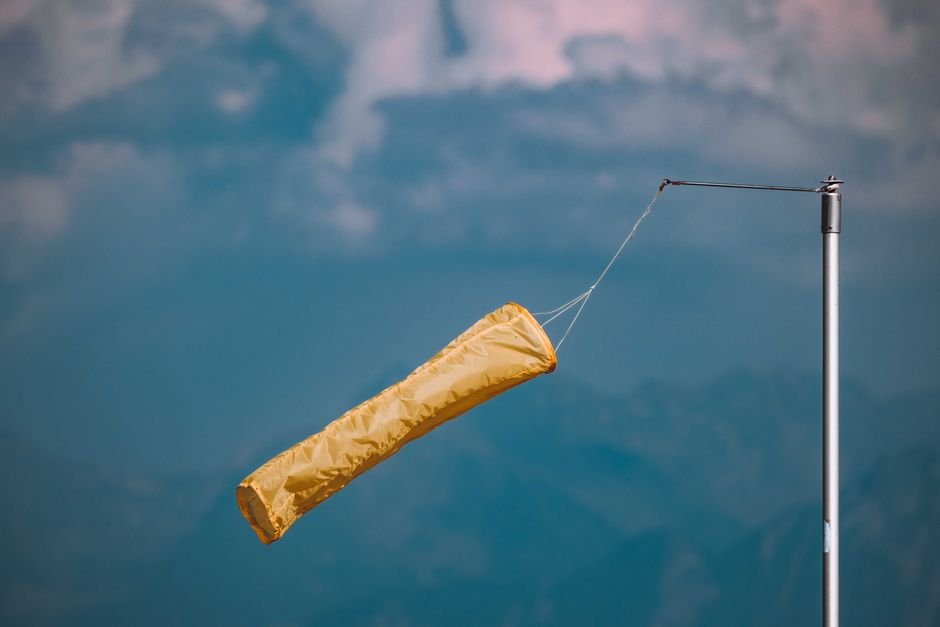 Jammu and Kashmir Weather: No Significant Activity Until August End; Hot, Humid Conditions Expected in September Yellow windsock blowing in the wind, mounted on a pole against a cloudy blue sky.