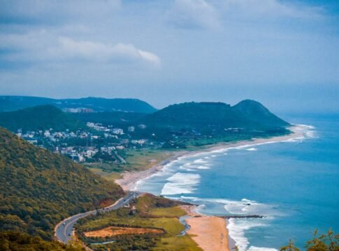 A breathtaking aerial view of the coastline in Visakhapatnam, capturing lush hills and the vibrant sea.