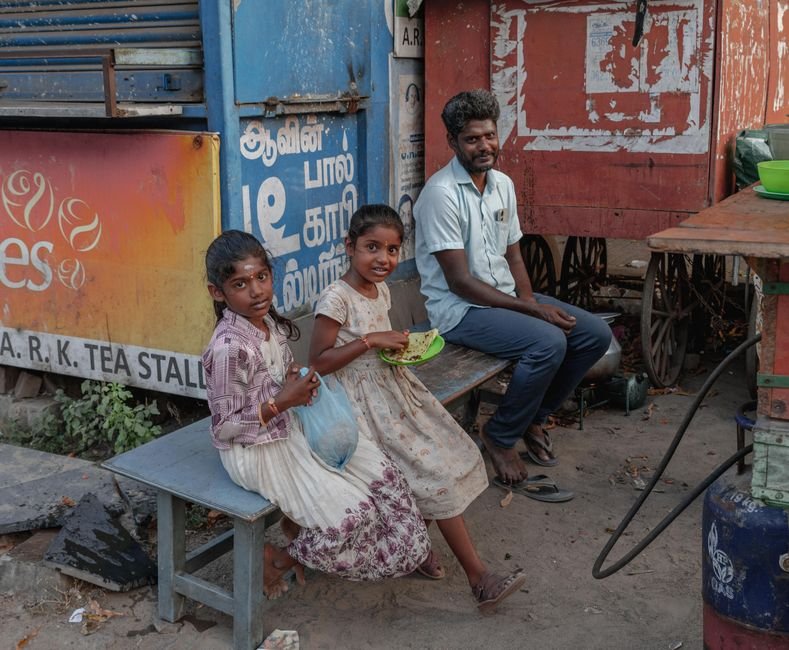 Tamil Nadu Expands Kamarajar Breakfast Scheme to Cover Classes VI-VIII A candid street scene featuring people outside a tea stall in Kanchipuram, Tamil Nadu.