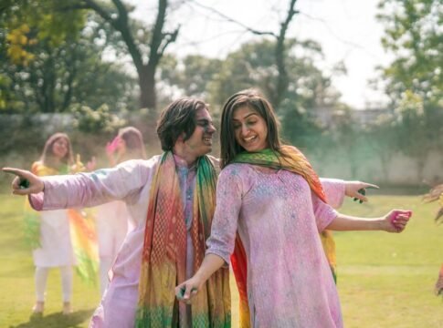 A cheerful group enjoying the Holi festival outdoors with colorful powders and smiles.