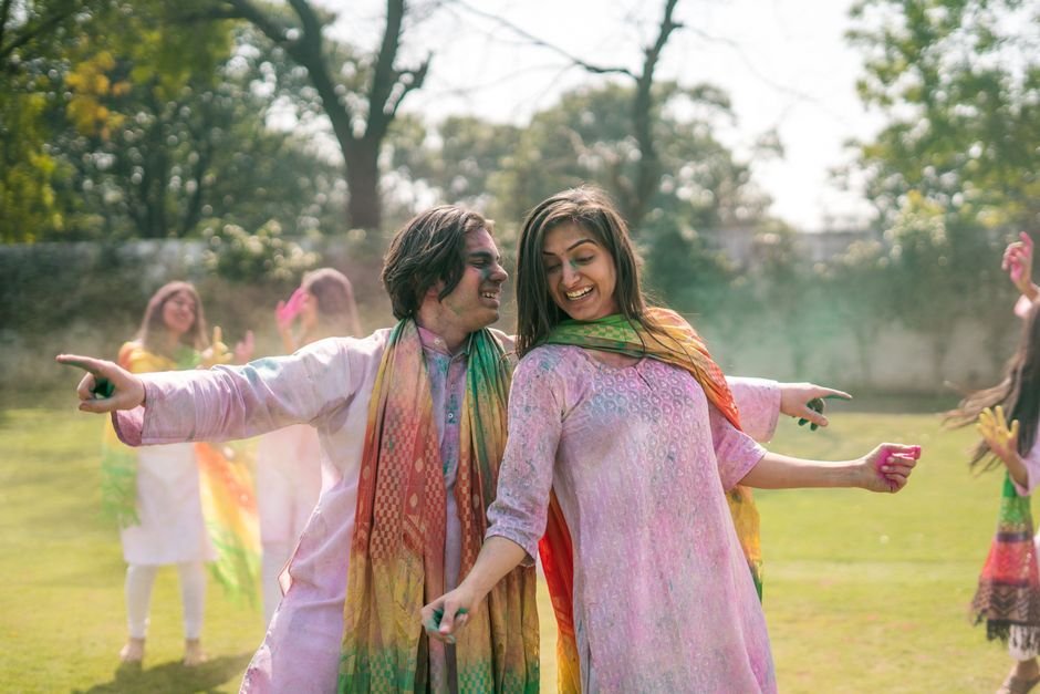 A cheerful group enjoying the Holi festival outdoors with colorful powders and smiles.