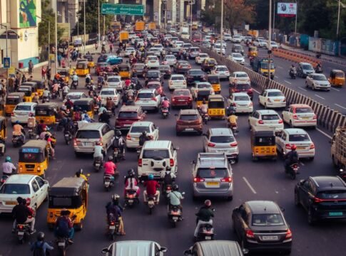 A crowded city street filled with cars, motorcycles, and buses during daytime rush hour. A crowded city street filled with cars, motorcycles, and buses during daytime rush hour.