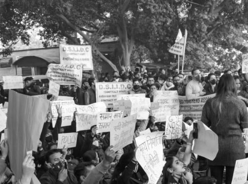 A grayscale image of protesters holding signs and placards during a demonstration. A grayscale image of protesters holding signs and placards during a demonstration.