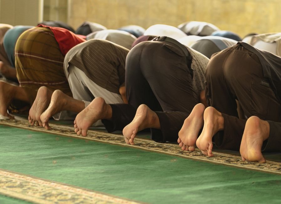 Islamic Principle of Creation in Pairs Emphasized A group of Muslim worshippers praying inside a mosque, captured from behind.