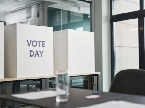 A modern office with voting booths labeled 'Vote Day' indicating election activity. A modern office with voting booths labeled 'Vote Day' indicating election activity.
