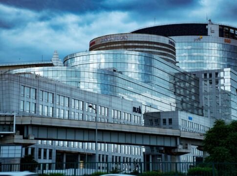 A sleek modern glass banking building in an urban city setting, showcasing reflective architecture.