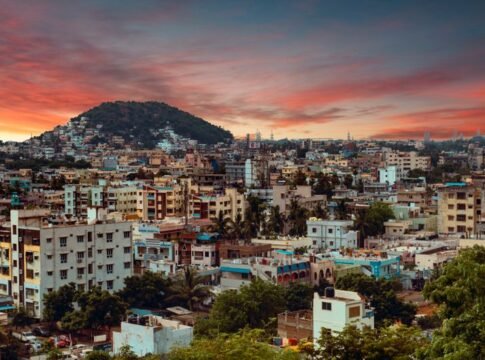 A vibrant sunset paints the sky over the bustling cityscape of Visakhapatnam, India. A vibrant sunset paints the sky over the bustling cityscape of Visakhapatnam, India.