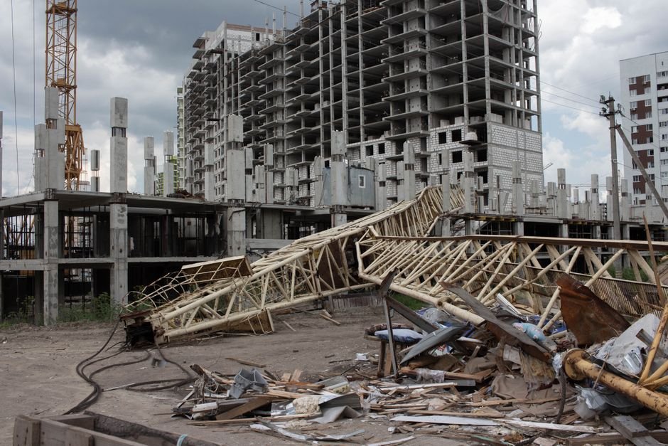 Tamil Nadu Church Construction Site Collapse Kills Three Workers, Injures 11 An urban construction site featuring a collapsed crane and unfinished buildings under cloudy skies.