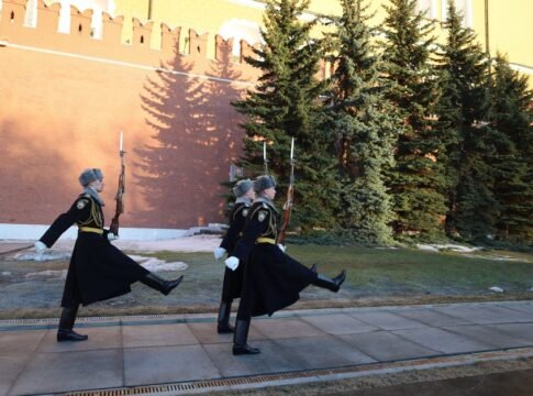 Ceremonial guards march outside the Kremlin walls in Moscow on a bright day. Ceremonial guards march outside the Kremlin walls in Moscow on a bright day.