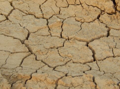 Close-up view of cracked, dry desert earth illustrating drought conditions. Close-up view of cracked, dry desert earth illustrating drought conditions.