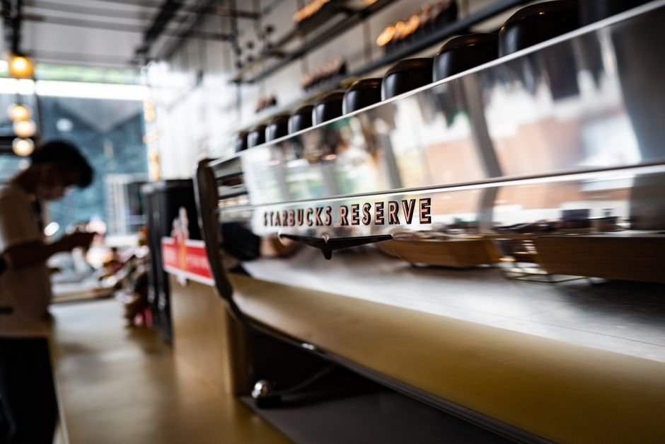 Starbucks to Establish Global Capability Centre in Chennai, Creating 800 Jobs Contemporary Starbucks Reserve coffeeshop interior featuring a sleek espresso machine with a reflective surface.