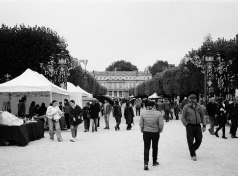 Crowds explore an outdoor market in Nancy, France, captured in black and white. Crowds explore an outdoor market in Nancy, France, captured in black and white.