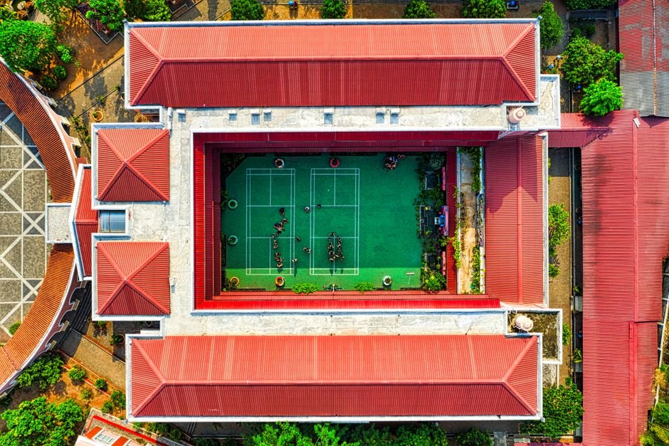 Madras HC: TNRERA Cannot Rule on Property Title Disputes; Civil Courts are the Proper Forum Drone view of a school courtyard with a green tennis court in Jakarta, Indonesia.