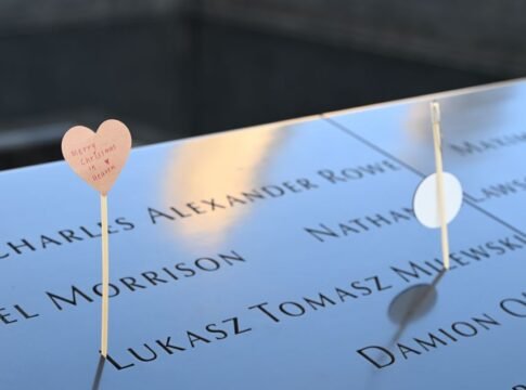 Emotional tribute with a heart card at a memorial displaying engraved names.