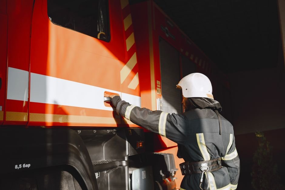 Tajikistan Establishes National Framework for Disaster Risk Data Governance Firefighter in safety gear working with a fire truck outdoors during the day.