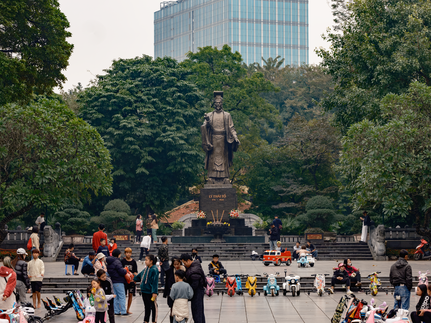 Lively scene at Lý Thái Tổ statue in Hanoi, showcasing cultural heritage.