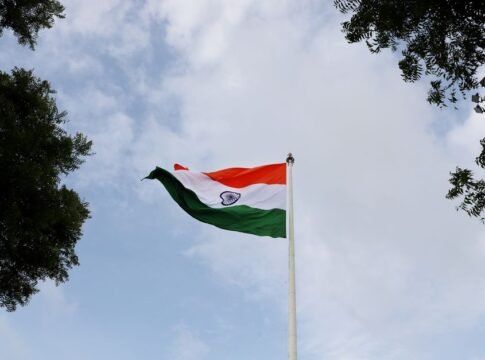 Low angle shot of the Indian national flag on a flagpole with a clear blue sky. Low angle shot of the Indian national flag on a flagpole with a clear blue sky.