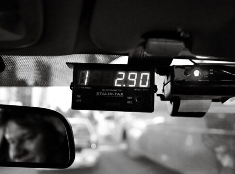 Moody black and white image of a taxi meter displaying fare inside a moving vehicle. Moody black and white image of a taxi meter displaying fare inside a moving vehicle.