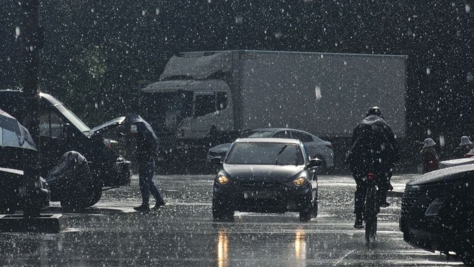 Uttar Pradesh and Uttarakhand on Red Alert as Heavy Rains Lash Northern India; Delhi Yellow Alerted Moody urban street scene in heavy rain with cars and pedestrians.