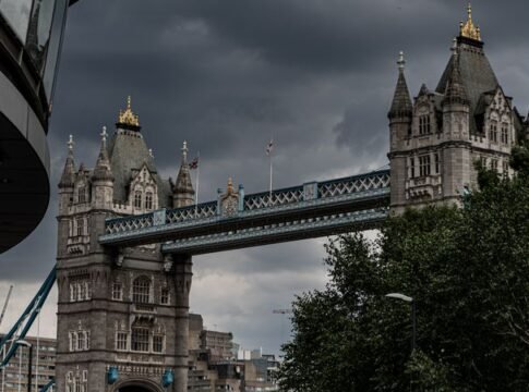 Scenic view of Tower Bridge in London, showcasing its majestic architecture under a dramatic sky.