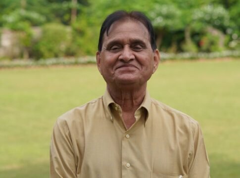 Senior man in a yellow shirt smiling outdoors in a lush green garden. Senior man in a yellow shirt smiling outdoors in a lush green garden.