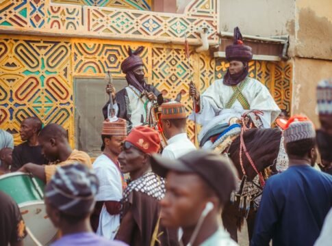 Vibrant street festival in Africa showcasing traditional attire and architecture.