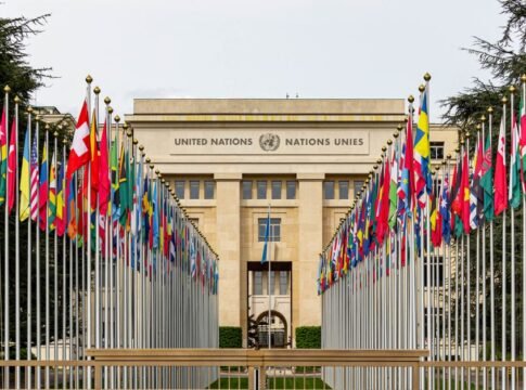 View of the United Nations Office in Geneva adorned with flags of various countries.