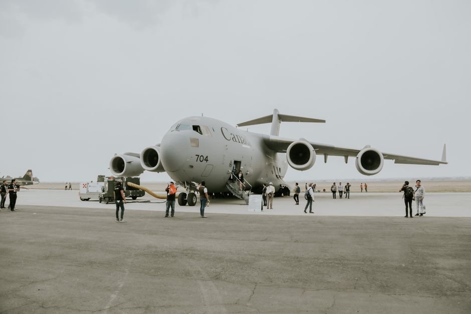 Fire Erupts at Canadian Military Base in Alberta After Deadly Incident A C-17 Globemaster military aircraft is stationed on an airfield with crew members and personnel nearby.