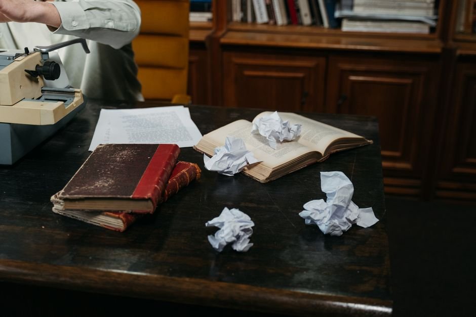 Punjab’s Hoshiarpur Celebrates Literary Excellence at All-India Mushaira A cozy workspace with typewriter, open books, and crumpled papers on a wooden desk, perfect for creative inspiration.