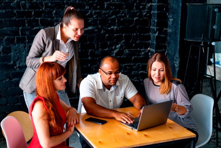 UK Amazon Quick User Group Fosters Growth and Collaboration in 2026 A diverse team of colleagues working together on a laptop in an office.
