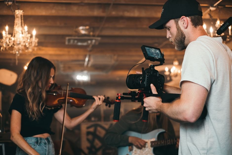 Singaporean Animated Film ‘The Violinist’ Secures Italian Co-Producers Through Tokyo Market Connections A filmmaker capturing a violinist on set, highlighting video production.