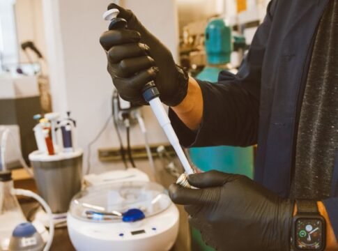 A lab technician performing an experiment with a pipette in a modern laboratory setting.