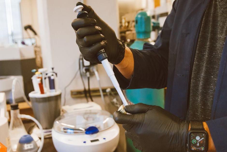 Bhupesh Kumar Gupta Appointed Head of Biotechnology Department at Nauni University, Himachal Pradesh A lab technician performing an experiment with a pipette in a modern laboratory setting.