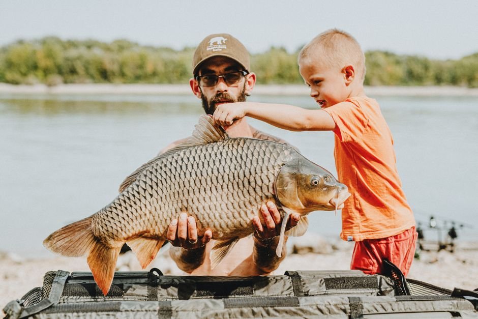 ‘Barry Loser’ Animated Series Gears Up for Production with New Italian Partnerships A man and a boy proudly display a carp caught by the lake on a sunny day.