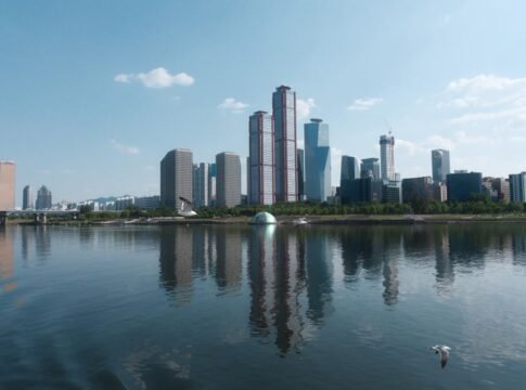 A stunning Seoul skyline reflecting in the river under a clear blue sky. A stunning Seoul skyline reflecting in the river under a clear blue sky.
