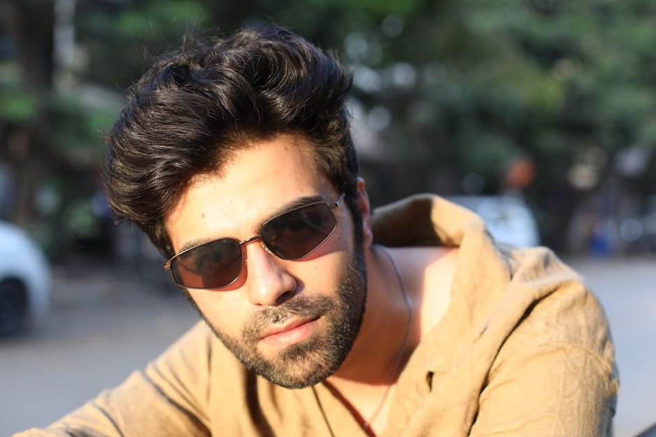 Ladakh Chief Secretary Assures Heli-Service Expansion to Remote Border Areas A young man with sunglasses confidently posing outdoors in sunlight.