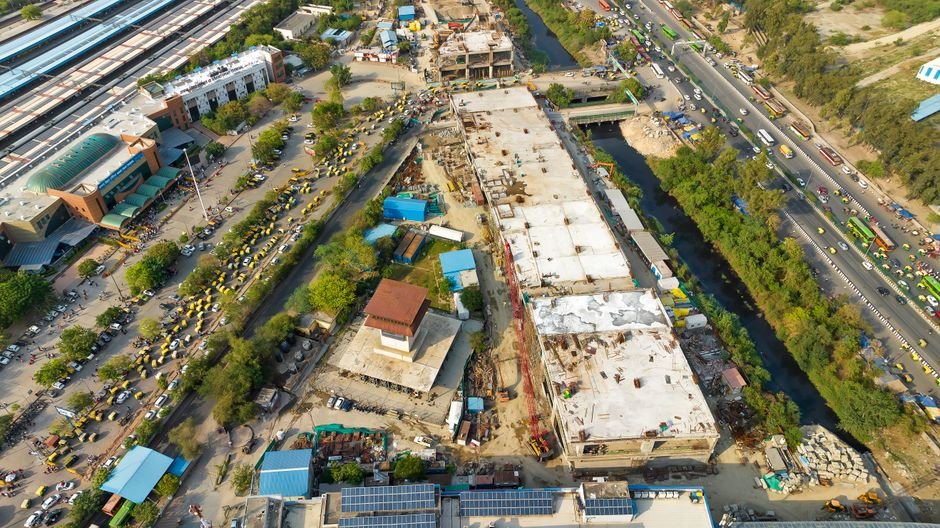 Punjab’s Kapurthala Approves ₹8.78 Crore for Road and Street Development Aerial shot of urban construction site alongside a bustling road and greenery.