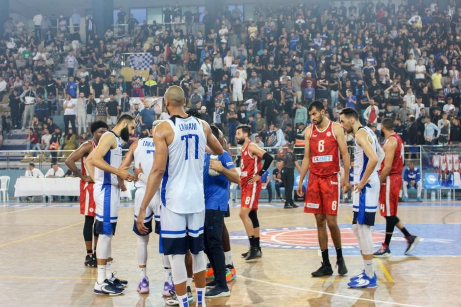 Ludhiana’s KCW Secures Fourth Consecutive Panjab University Basketball Title Basketball players in action during a competitive match with a full stadium crowd.