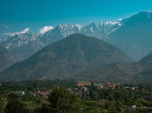 Breathtaking mountain range with valley and cityscape under clear blue sky. Breathtaking mountain range with valley and cityscape under clear blue sky.