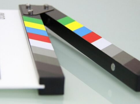 Colorful clapper board on a white surface, used in filmmaking. Ideal for entertainment and movie themes. Colorful clapper board on a white surface, used in filmmaking. Ideal for entertainment and movie themes.